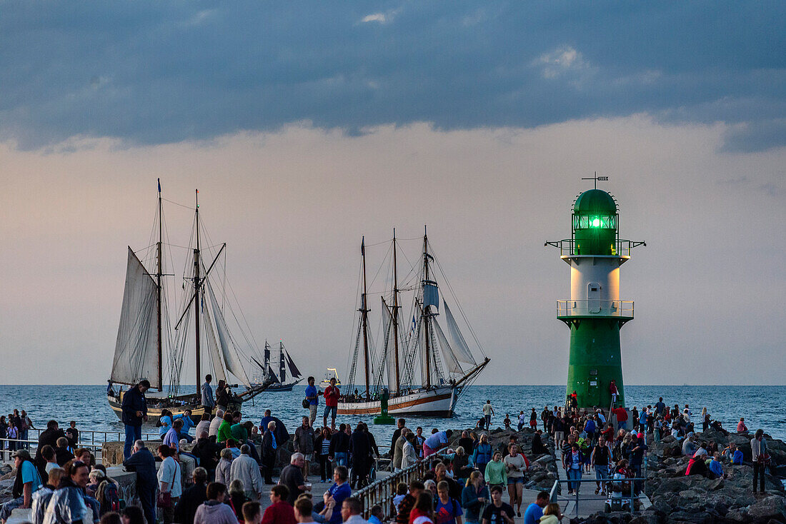 Sailboats in Warnemünde with onlookers and lighthouse to the Hanse Sail, Warnemünde, Rostock, Baltic Sea coast, Mecklenburg-Vorpommern, Germany