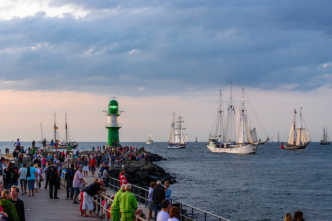 Sailboats in Warnemünde with onlookers and lighthouse to the Hanse Sail, Warnemünde, Rostock, Baltic Sea coast, Mecklenburg-Vorpommern, Germany