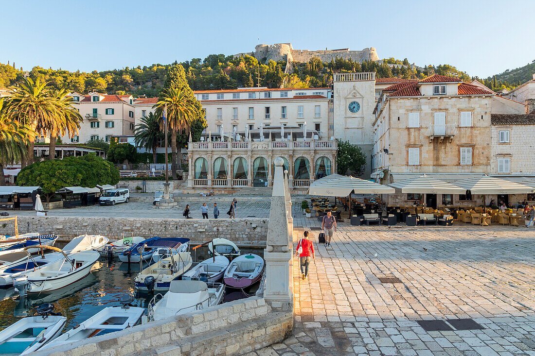 The main square (Trg Svetog Stjepana) of Hvar Town with view to the Spanish Fortress in the background at first sunlight, Hvar, Croatia, Europe
