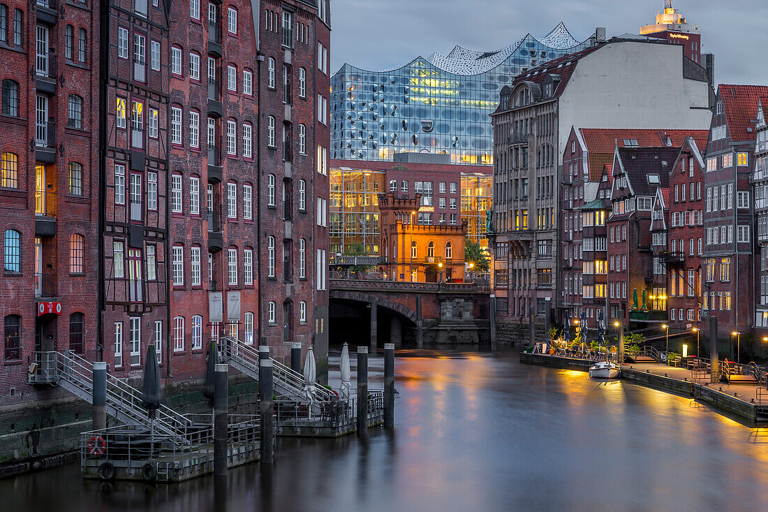 Historical buildings at Nikolaifleet with view to the Elbphilharmonie building in the background at dusk, Hamburg, Germany, Europe