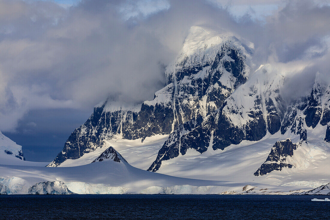 Glaciers and mountains of Cape Errera with dramatic sky, Wiencke Island, from Bismarck Strait, Antarctic Peninsula, Antarctica, Polar Regions