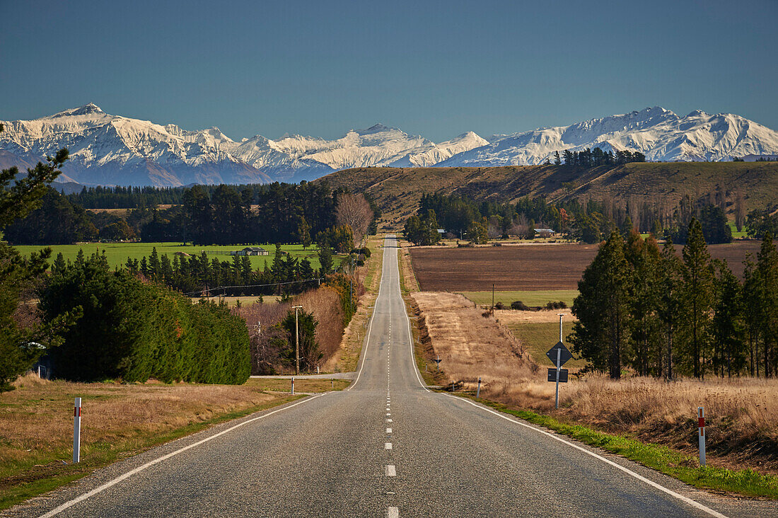 Open road on State Highway 6 near Cromwell, Central Otago with views to the ski fields at Wanaka, Otago, South Island, New Zealand, Pacific