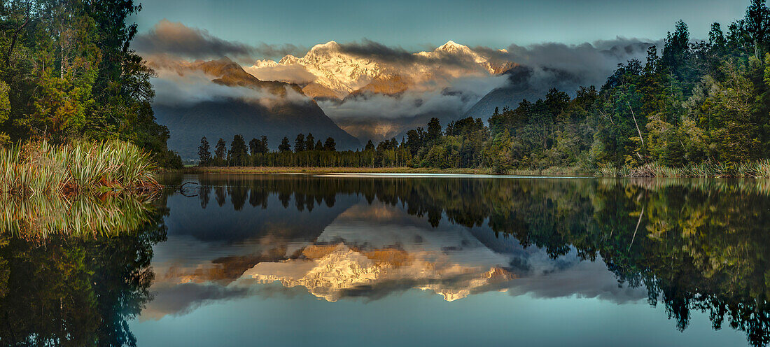 Mountains reflected in lake at sunset, Lake Matheson, Mount Tasman and Mount Cook, Westland National Park, South Island, New Zealand