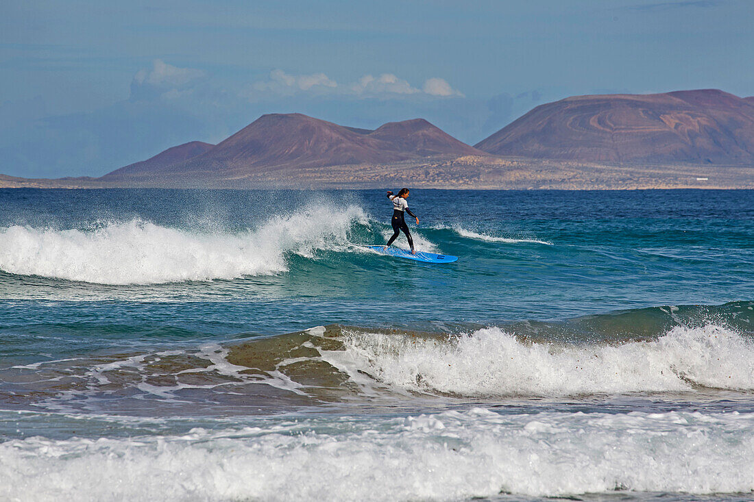 Surfer am Playa de Famara, Atlantik, Lanzarote, Kanaren, Kanarische Inseln, Islas Canarias, Spanien, Europa