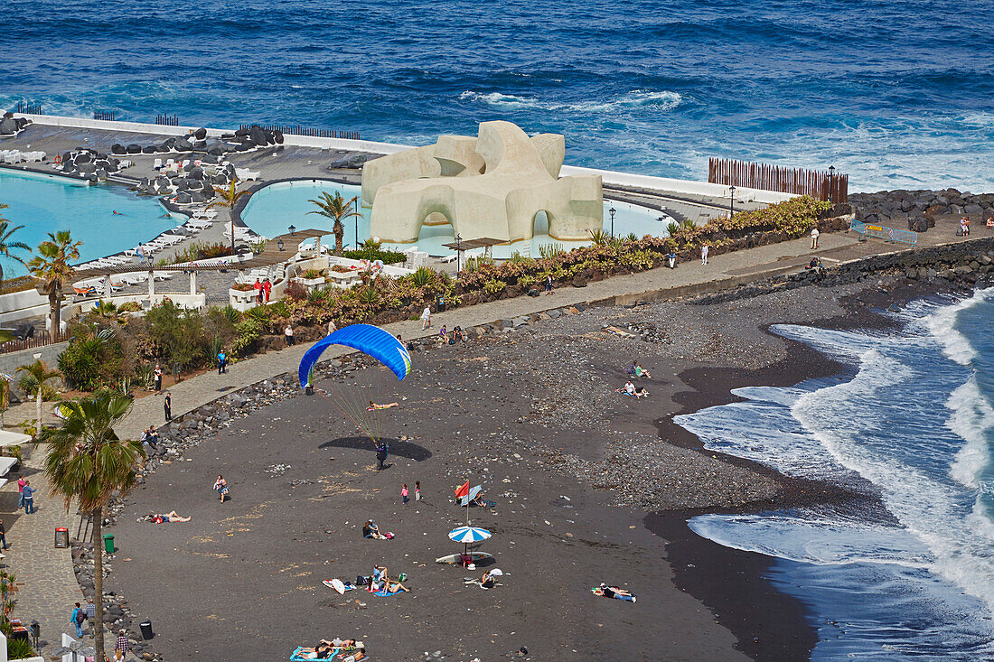 Paraglider landet am öffentlichen Strand von Puerto de la Cruz, Badelandschaft Lago Martianez César Manrique, Teneriffa, Kanaren, Kanarische Inseln, Islas Canarias, Atlantik, Spanien, Europa