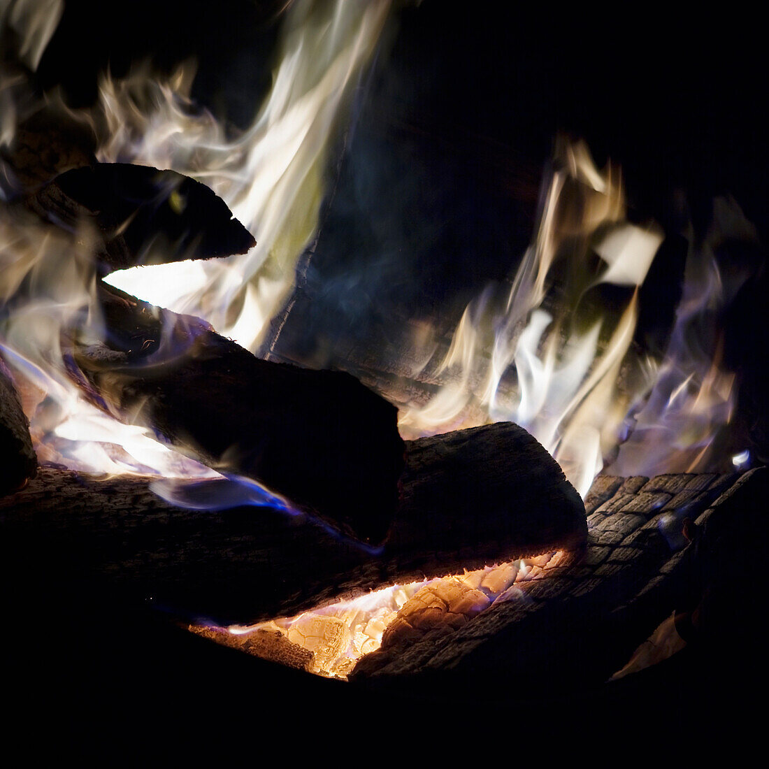 Close up of the colorful embers and flames of a wood fire.