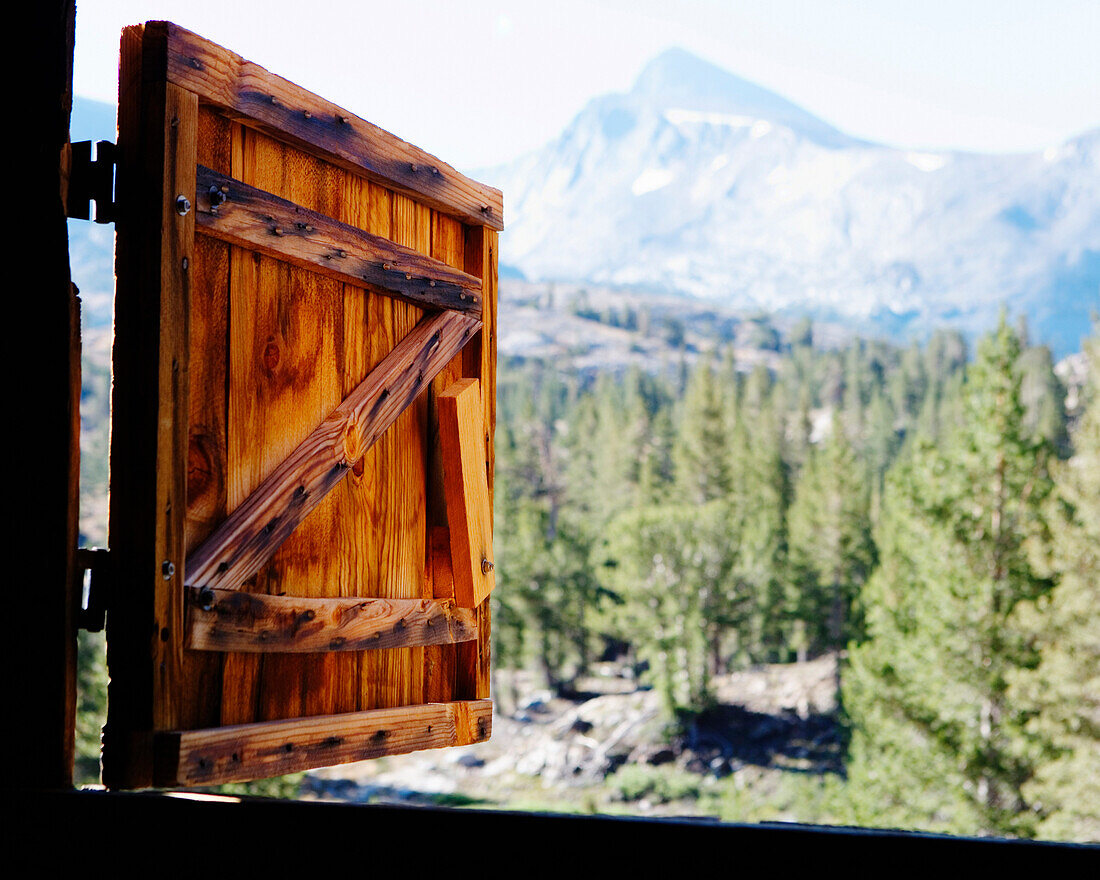 View of the mountains in Yosemite National Park though a open, wooden barn window. California, USA.