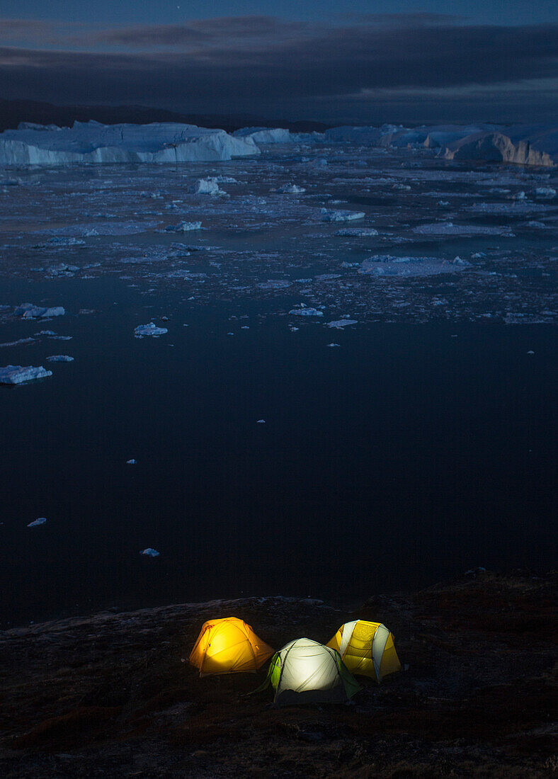 Icy but beautiful night time camping along the shores of the Ilulissat Icefjord in Greenland.  This area is home to some of the world's largest icebergs.