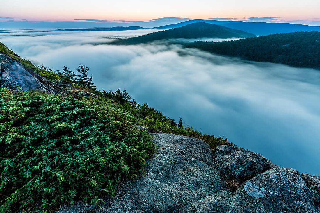 Scenery with view from mountain of fog rising from Echo Lake at dawn in Acadia National Park, Maine, USA