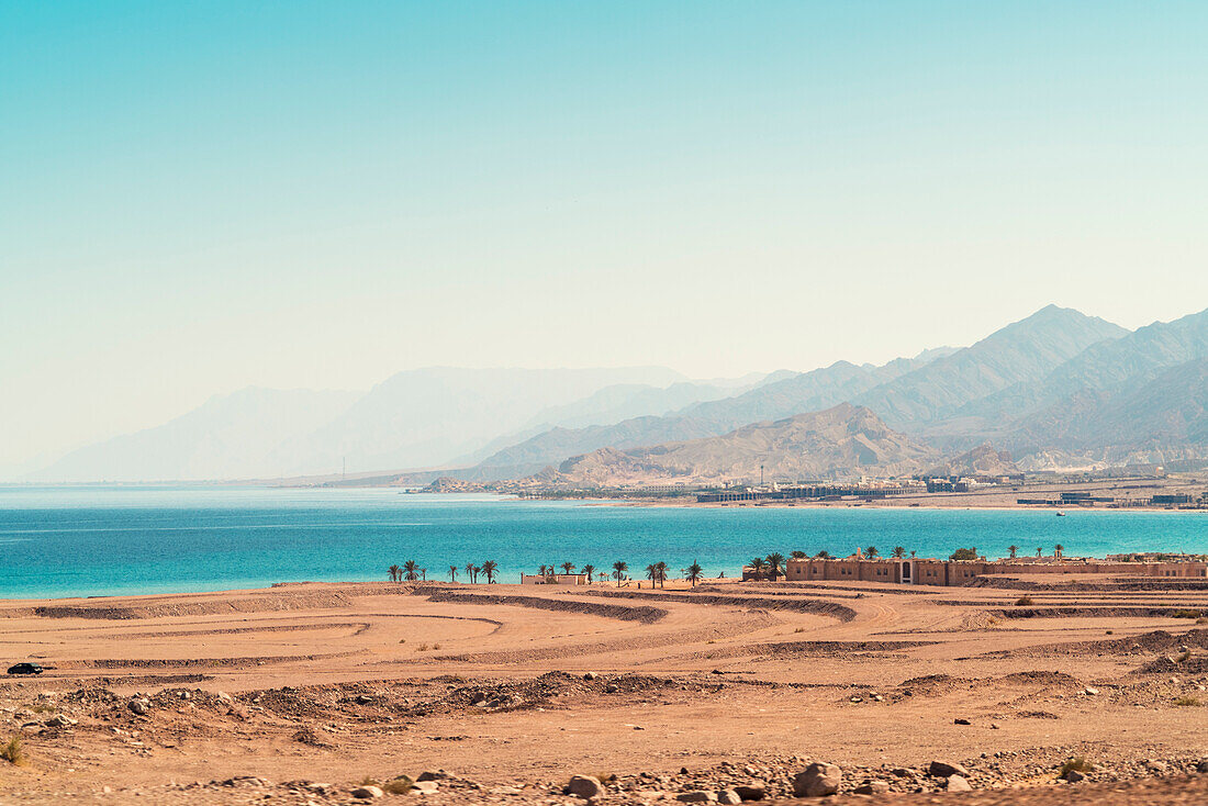 Bay close to Nuweiba city with palm trees and mountains on background, Nuweiba, Southern Sinai, Egypt