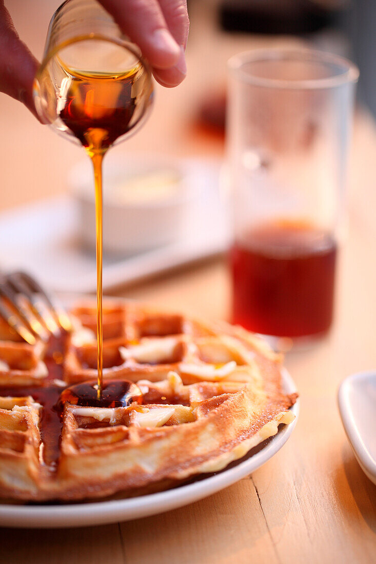 Person pouring honey over waffles, Chelsea, Manhattan, New York City, USA