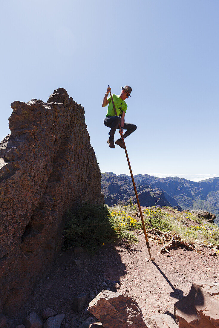 Springen mit dem Kanarischen Hirtenstab, Mann, Salto del Pastor Canario, Pared de Roberto, Basaltfelswand, Kraterrand der Caldera de Taburiente, UNESCO Biosphärenreservat, La Palma, Kanarische Inseln, Spanien, Europa