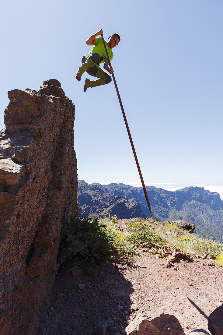 Springen mit dem Kanarischen Hirtenstab, Mann, Salto del Pastor Canario, Pared de Roberto, Basaltfelswand, Kraterrand der Caldera de Taburiente, UNESCO Biosphärenreservat, La Palma, Kanarische Inseln, Spanien, Europa