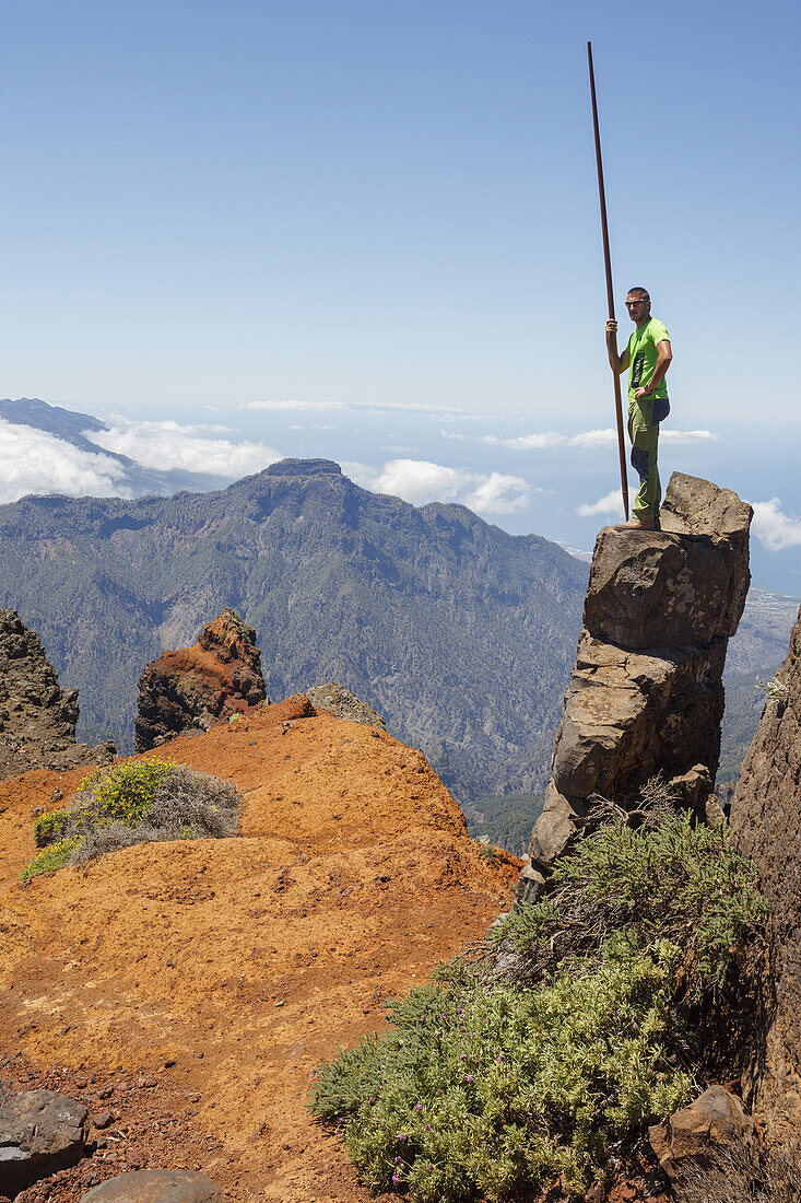 man on a summit, jumping with the canarian crook, Salto del Pastor Canario, crater rim, Caldera de Taburiente, UNESCO Biosphere Reserve, La Palma, Canary Islands, Spain, Europe
