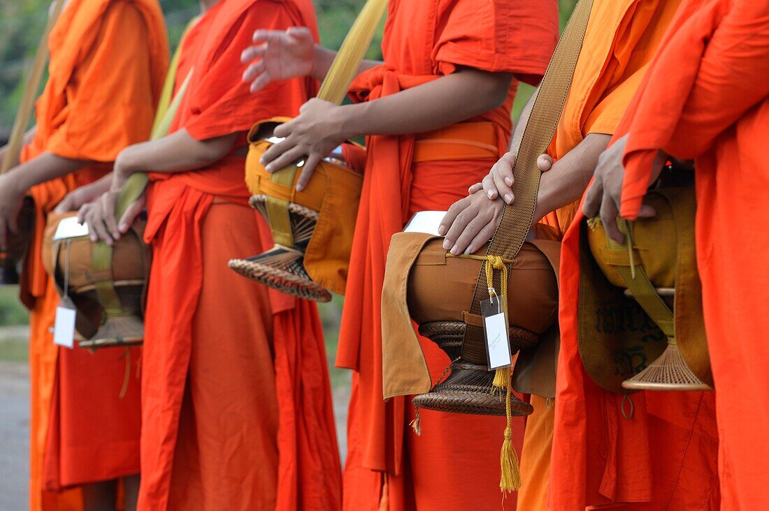 Buddhist monks walking along road to collect alms, Four Thousand island,South Laos,Southeast Asia.