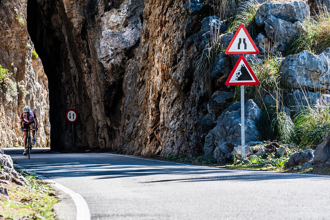 Ein Radfahrer auf der berühmten Serpentinenstrasse die zum Torrent de Pareis führt, Sa Calobra, Tramuntana Gebirge, Mallorca, Spanien