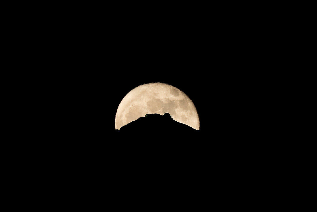 Silhouette of Grigna Settentrionale mountain summit highlighted by the moon, province of Lecco, Lombardy, Italy