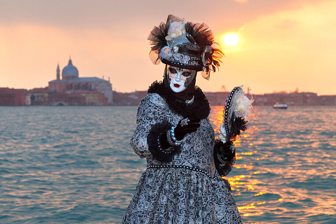 Typical mask of Carnival of Venice at San Giorgio island with Redeemer Church on background, Venice, Veneto, Italy