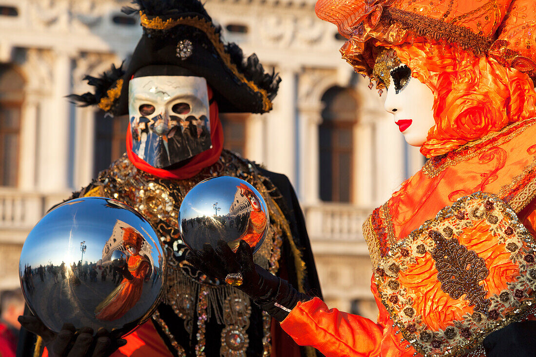 A couple of typical mask of Carnival of Venice with reflective spheres at San Marco square, Venice, Veneto, Italy