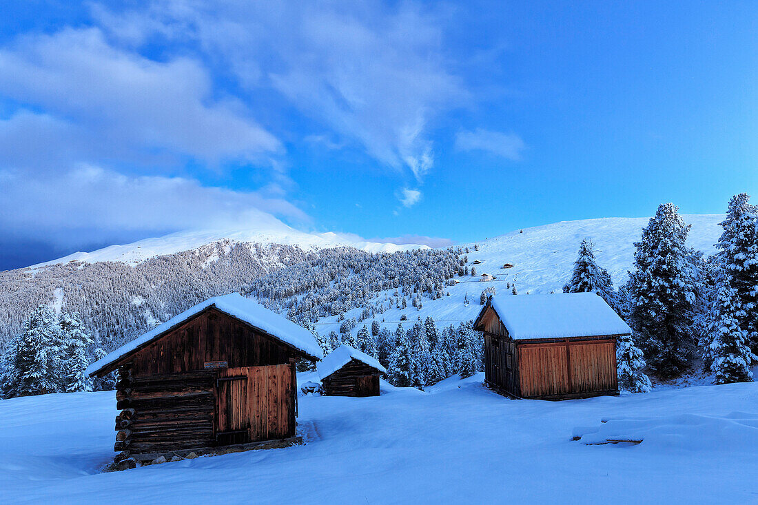 Old snow-covered huts during twilight. Erbe Pass, Funes Valley, South Tyrol, Dolomites, Italy