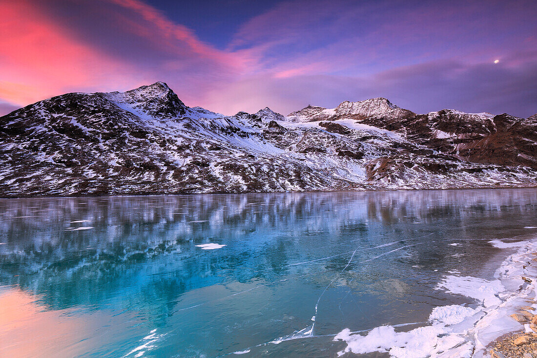 Stunning sunrise on the frozen Lago Bianco(White Lake), Bernina Pass, Engadine, Graubünden, Switzerland.