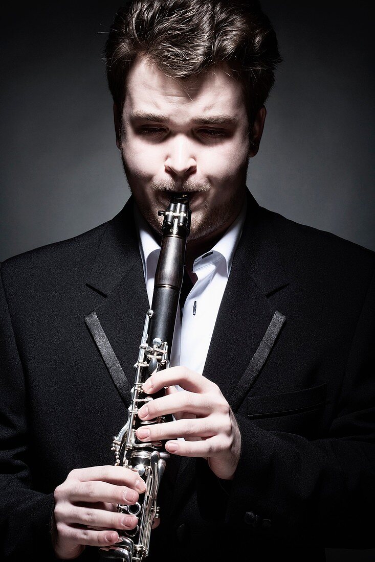 Portrait of Young Male Musician Playing Clarinet.