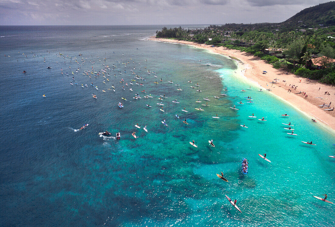 Paddleboarders lining up for paddle board race from Sunset Beach to Waimea Bay, Oahu, Hawaii, USA