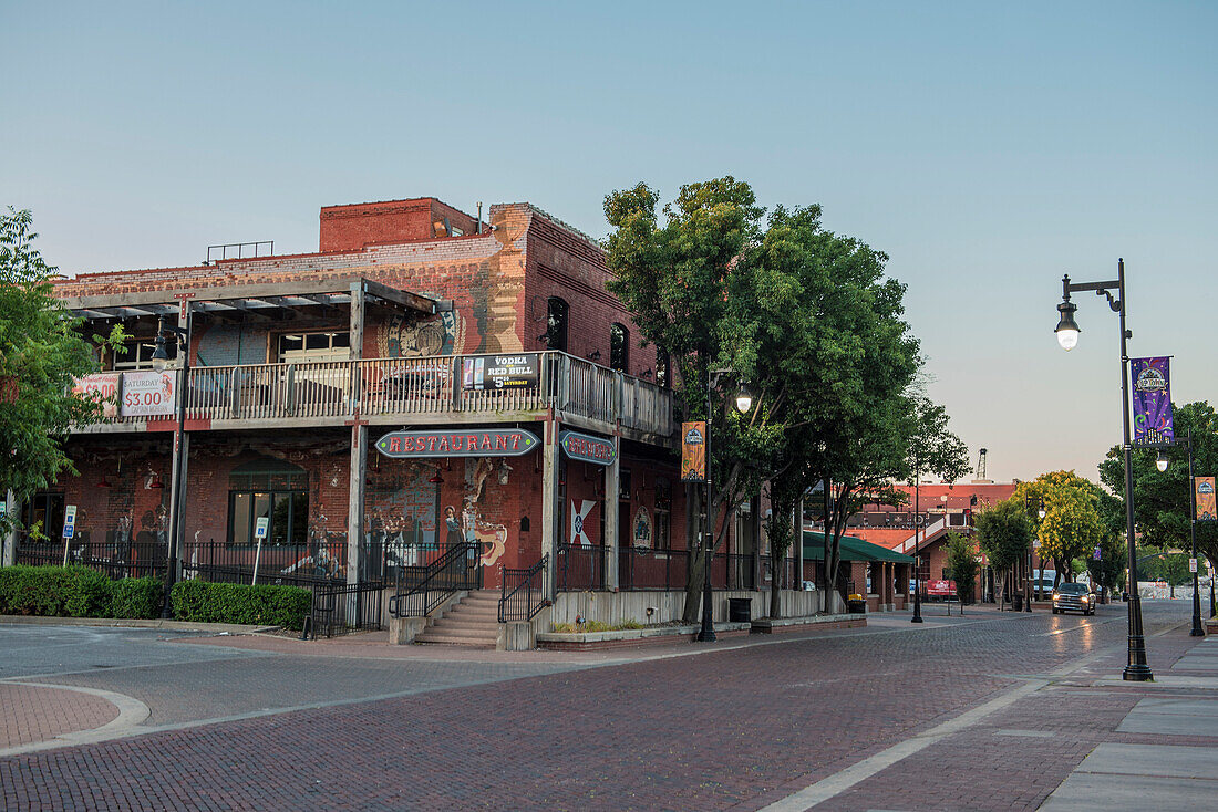 Street in old town of Wichita under clear sky with restaurant, Kansas, USA