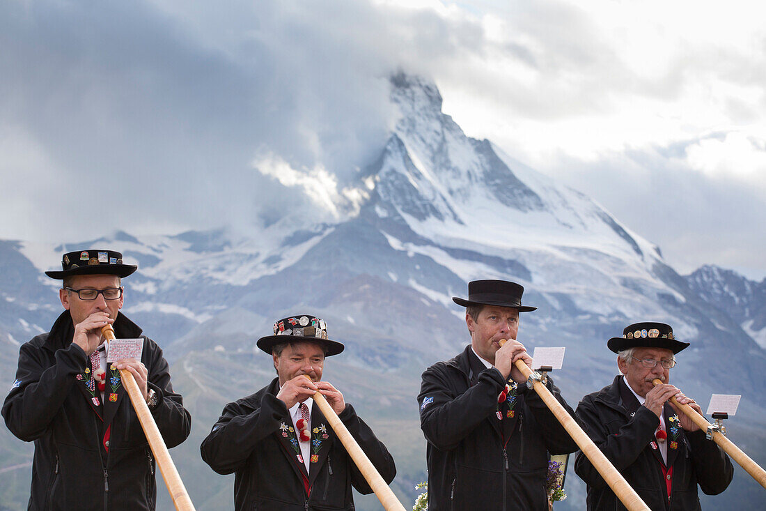 Four traditionally dressed locals of Zermatt play the Alphorn in front of the Matterhorn mountain.     With the passing of time, the alphorn almost totally disappeared as an instrument used by Swiss shepherds. It was only with the romanticism of the 19th 