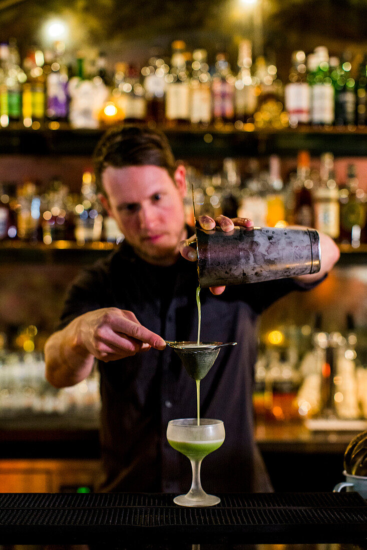 A bartender makes a fancy cocktail at a swanky bar in Seattle's Capital Hill neighborhood.