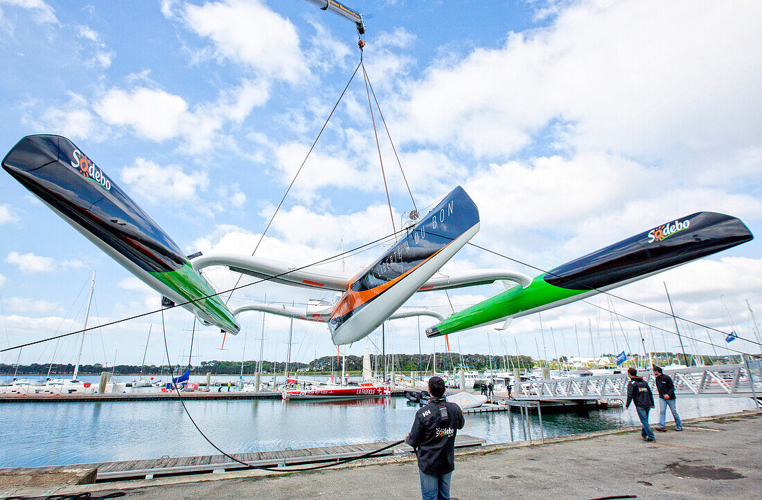 Crane lifting trimaran before being relaunched, Lorient, Brittany, France