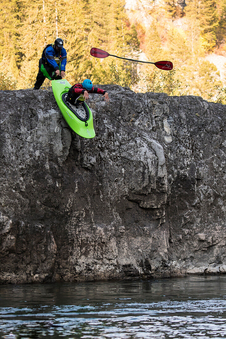 Kayaker loses paddle while falling down from rocky wall into river, Jackson Hole, Wyoming, USA