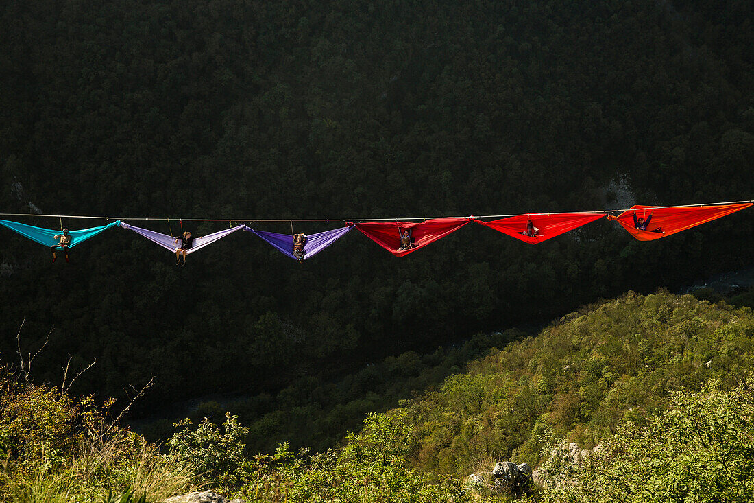 Side view of people lying in hammocks and hanging on high line, Tijesno Canyon, Banja Luka, Bosnia and Herzegovina
