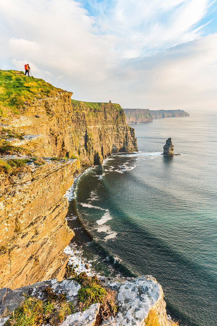 Photographer on the edge of the Cliffs of Moher, Liscannor, Co. Clare, Munster province, Ireland.