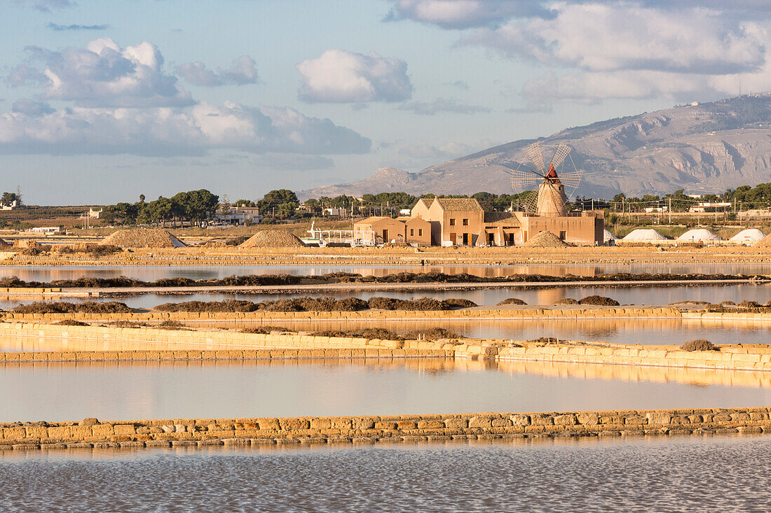 Salt pans in front of Infersa windmill on the coast connecting Marsala to Trapani, Trapani province,Sicily,Italy