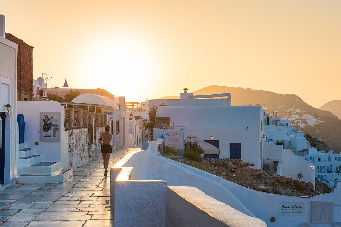 Oia,Santorini,Cyclades,Greece Girl runs through the village of Oia at dawn