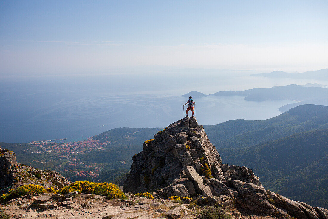 Hiker admires the sea from the top of Monte Capanne, Elba Island, Livorno Province, Tuscany, Italy