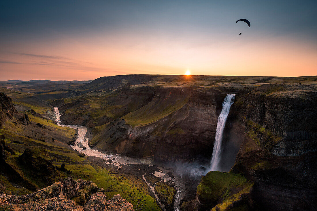 Paragliding over Haifoss waterfall at Fossa river at sunset, Southern Iceland, Iceland