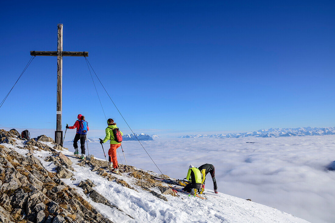 Two women backcountry skiing ascending towards Hinteres Sonnwendjoch, fog in the valley, Hinteres Sonnwendjoch, Bavarian Alps, Tirol, Austria