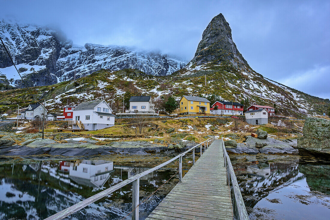 Wooden bridge leading towards Norwegian houses and mountains, Matterhorn of Lofoten, Reine, Lofoten, Nordland, Norway