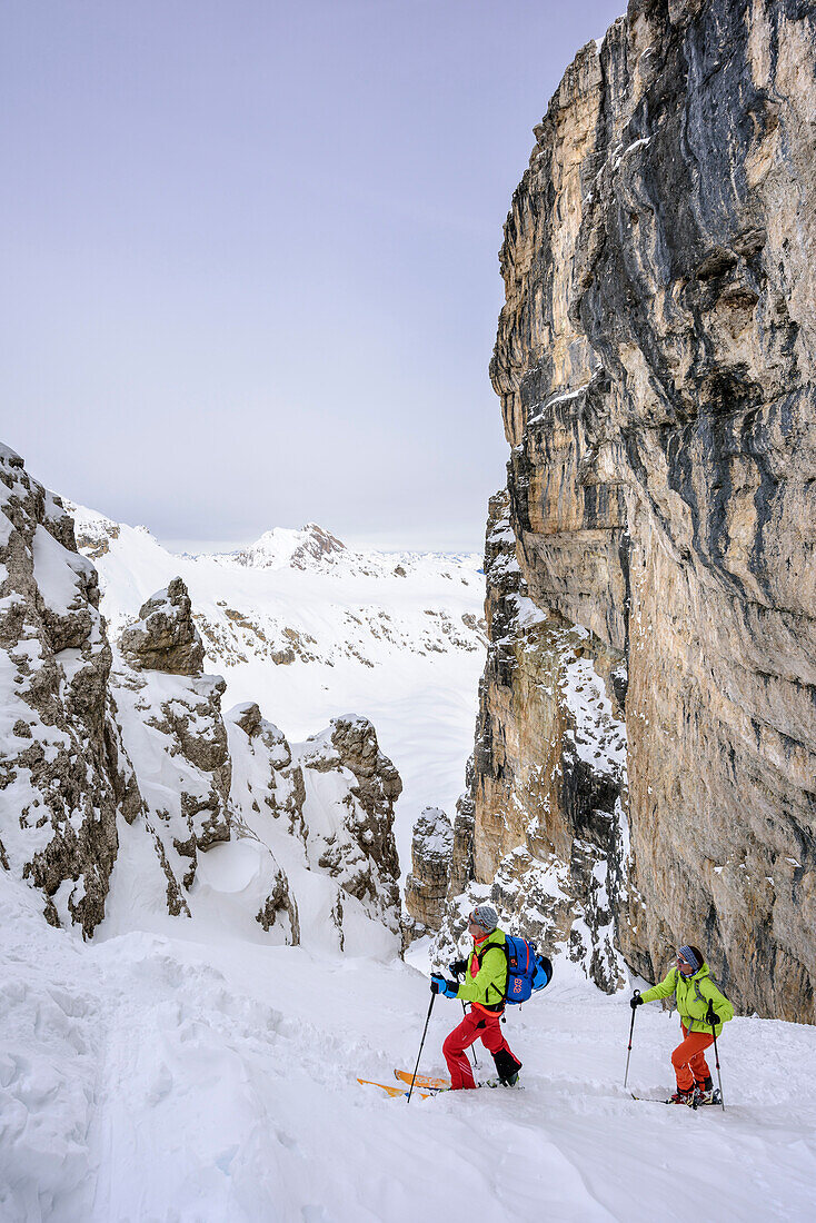 Two persons backcountry skiing ascending through canyon to Puezspitze, Puezspitze, Natural Park Puez-Geisler, UNESCO world heritage site Dolomites, Dolomites, South Tyrol, Italy