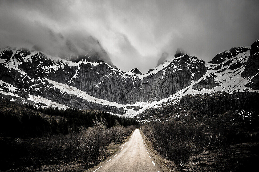 Strasse Richtung Berge auf Flakstadoya, Lofoten, Norwegen