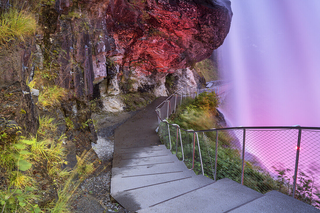 Hinter dem beleuchteten Wasserfall Steinsdalsfossen in Norheimsund, Hardanger, Hordaland, Fjordnorwegen, Südnorwegen, Norwegen, Skandinavien, Nordeuropa, Europa