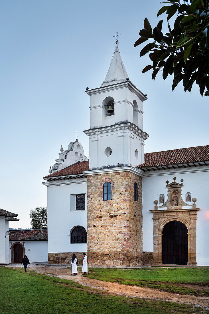 weiß gekleidete Nonnen unterhalten sich vor katholischer Kirche Iglesia del Carmen, Villa de Leyva, Departamento Boyacá, Kolumbien, Südamerika