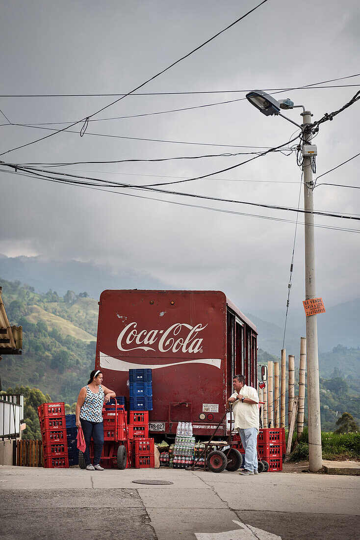 zwei Einheimische unterhalten sich vor Coca Cola Getränkewagen, Salento, UNESCO Welterbe Kaffee Dreieck (Zona Cafatera), Departmento Quindio, Kolumbien, Südamerika