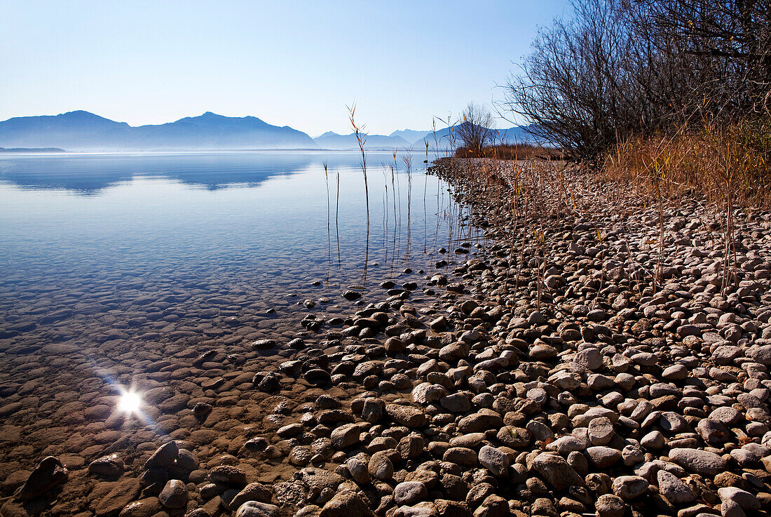 Shallow Water beside a gravel bank in Lake Chiemsee and the Chiemgau mountains in the background