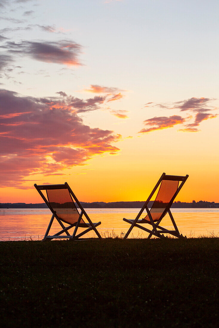 Two deck chairs in the last evening light at the Chiemsee beach at Feldwies