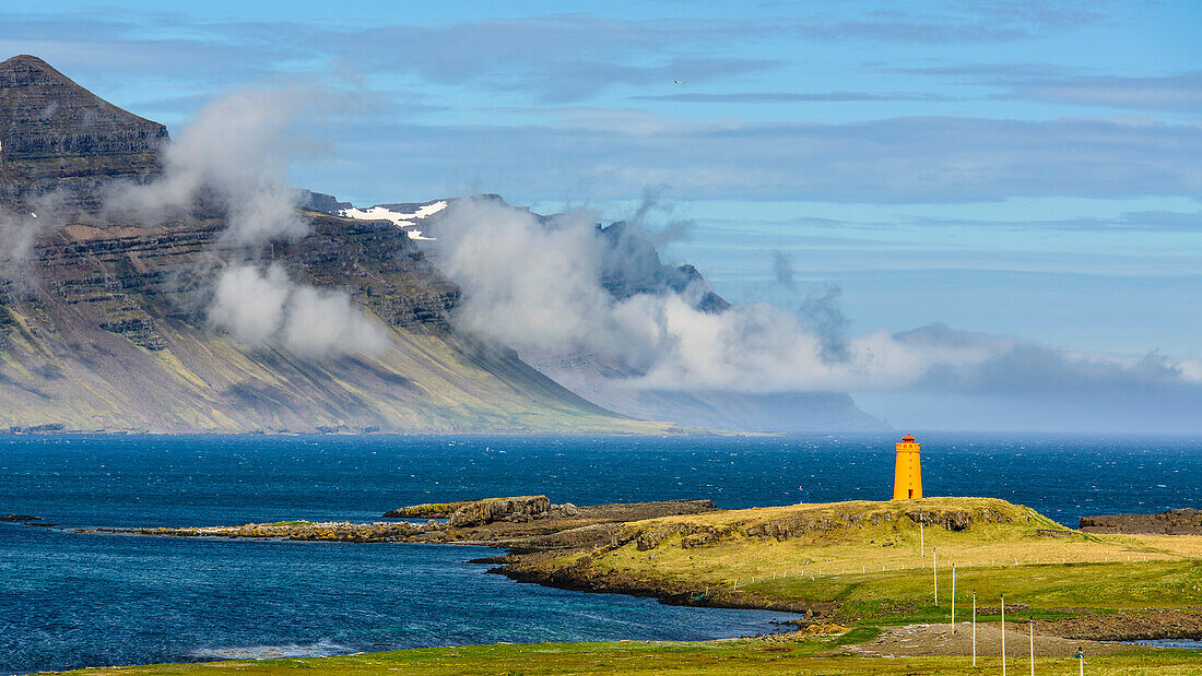 Kleiner orangener Leuchtturm an den Ostfjorden Islands
