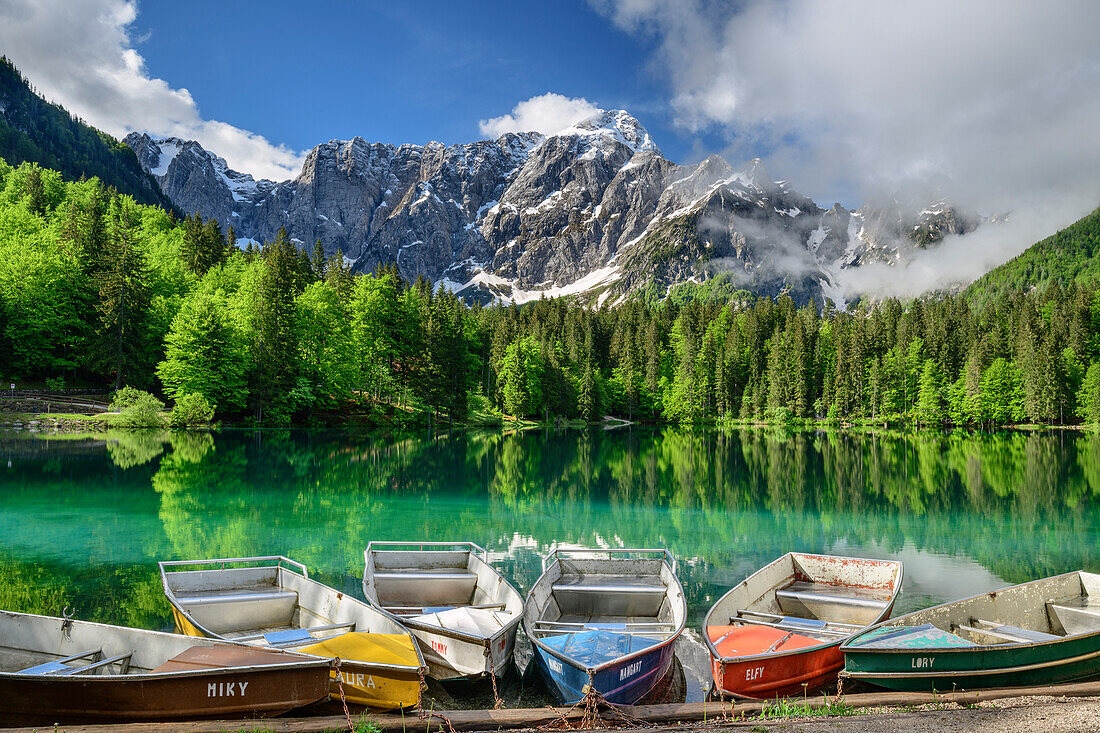 Colourful boats laying in lake Fusine, Mangart in background, Lago Fusine, Julian Alps, Friuli, Italy