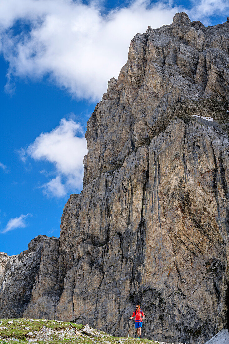 Frau beim Wandern vor Felswand, Passo della Cavalla, Val Maira, Cottische Alpen, Piemont, Italien